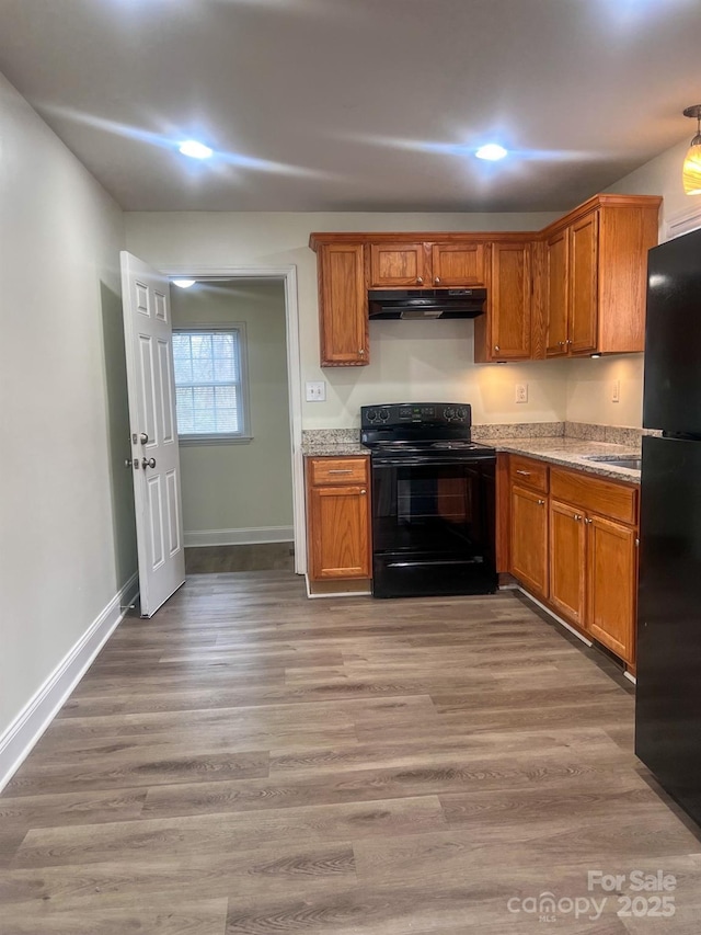 kitchen featuring sink, light wood-type flooring, and black appliances