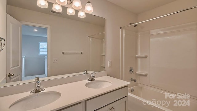 bathroom featuring vanity with extensive cabinet space, dual sinks, and shower / bathing tub combination