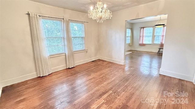 unfurnished room with ornamental molding, a wealth of natural light, and hardwood / wood-style floors