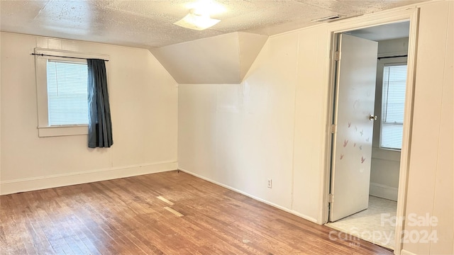 bonus room featuring a textured ceiling, vaulted ceiling, and hardwood / wood-style flooring