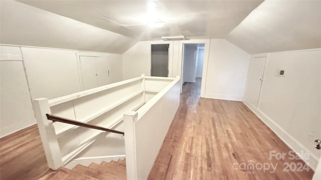 additional living space with wood-type flooring and lofted ceiling