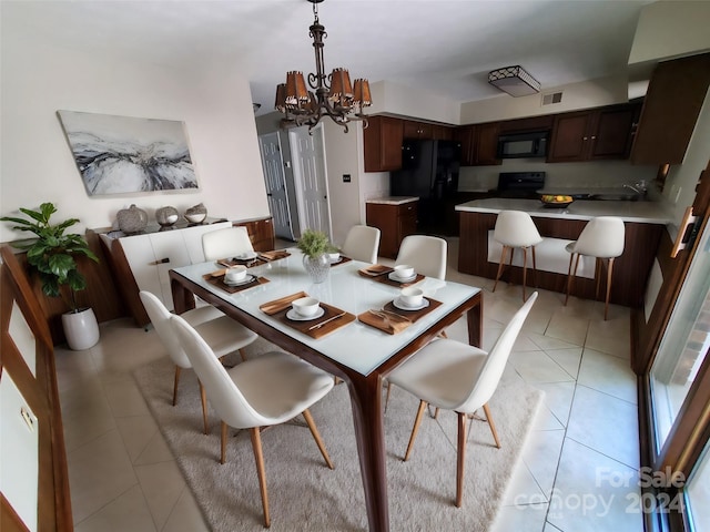 tiled dining space with sink and a notable chandelier