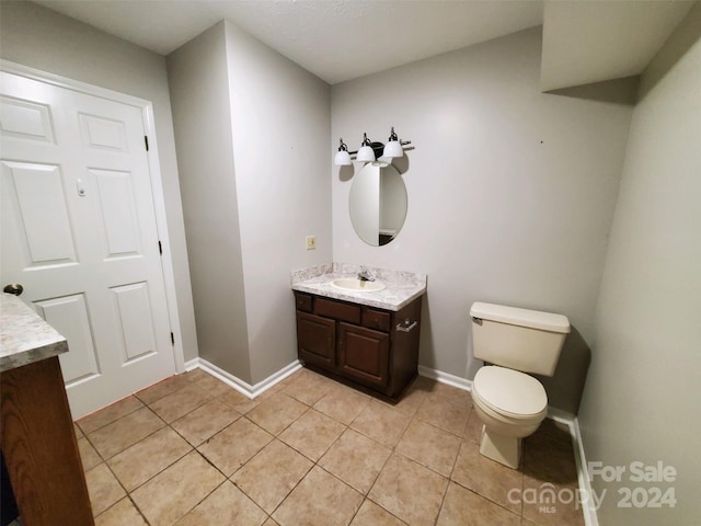 bathroom featuring tile patterned floors, toilet, and vanity