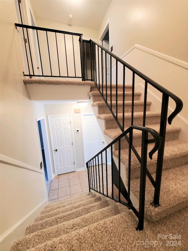 stairway featuring tile patterned flooring