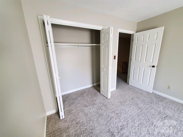 interior space with a closet and light colored carpet