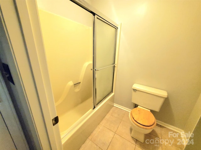 bathroom with toilet, tile patterned floors, and enclosed tub / shower combo