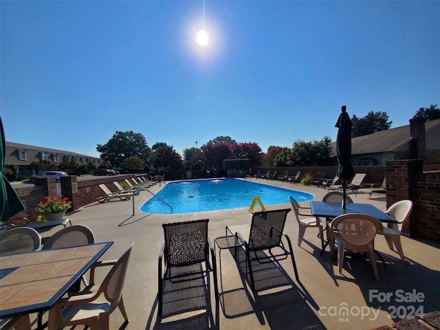 view of pool featuring pool water feature and a patio