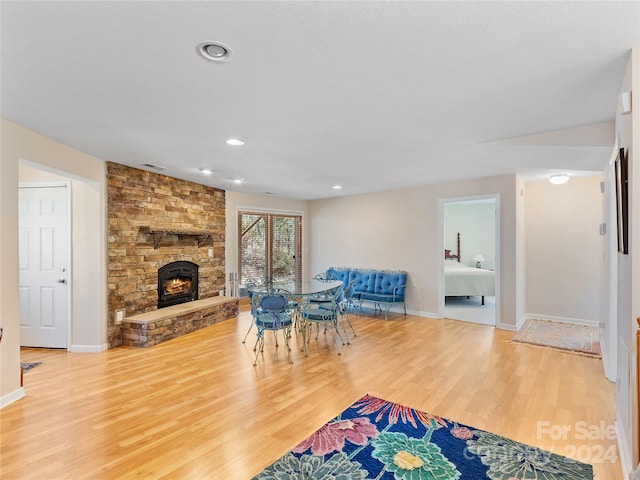 living room featuring light hardwood / wood-style floors and a stone fireplace