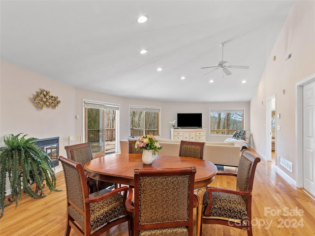 dining room with high vaulted ceiling, ceiling fan, and light hardwood / wood-style flooring