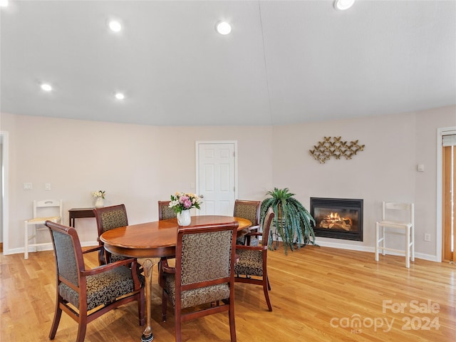 dining area featuring lofted ceiling and light hardwood / wood-style flooring