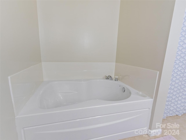 bathroom with a washtub and tile floors