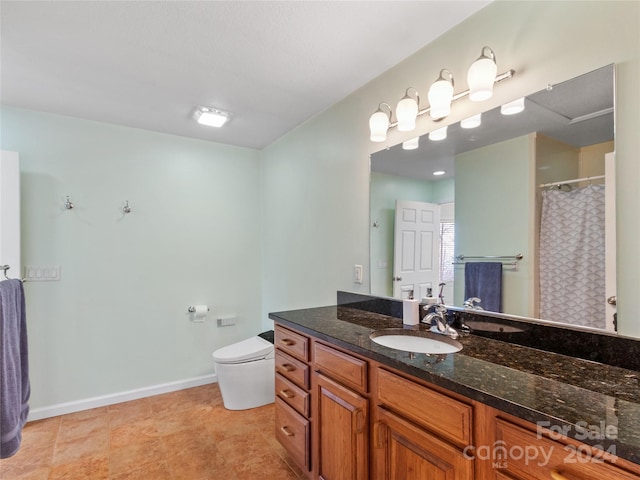 bathroom with toilet, vanity, and tile flooring