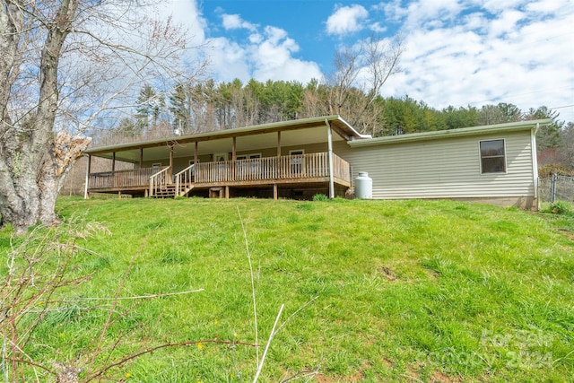 rear view of house featuring a yard and a deck