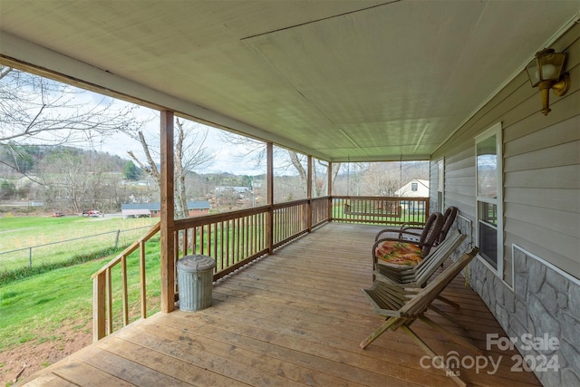 wooden terrace with a lawn