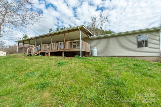 rear view of property with a wooden deck and a lawn