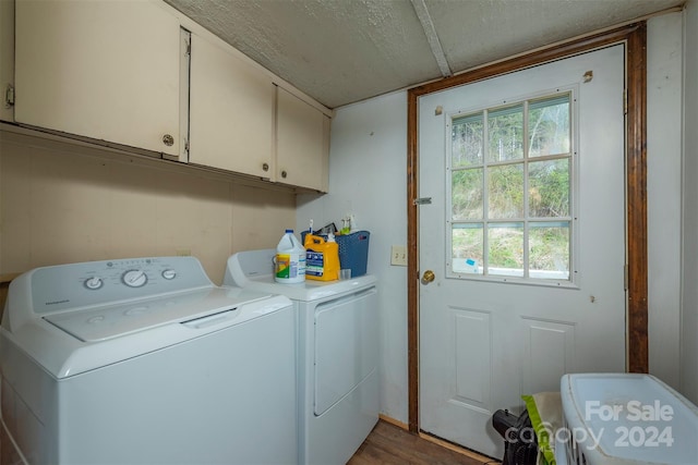 clothes washing area with washing machine and clothes dryer, cabinets, plenty of natural light, and hardwood / wood-style flooring