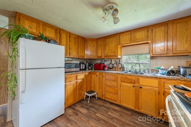 kitchen with ceiling fan, white fridge, stove, dark hardwood / wood-style flooring, and tasteful backsplash