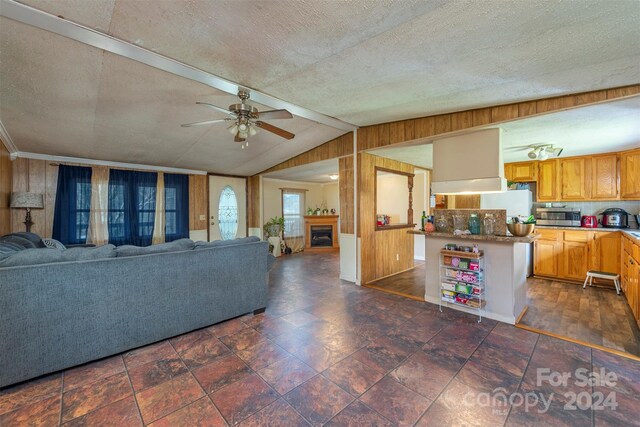 living room featuring dark tile flooring, a textured ceiling, ceiling fan, and lofted ceiling