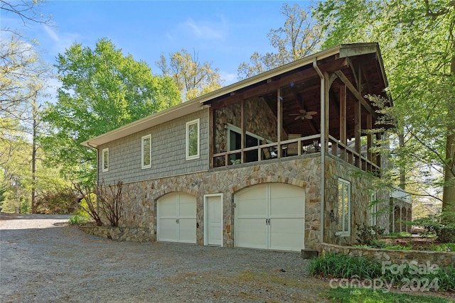 view of side of property with ceiling fan and a garage