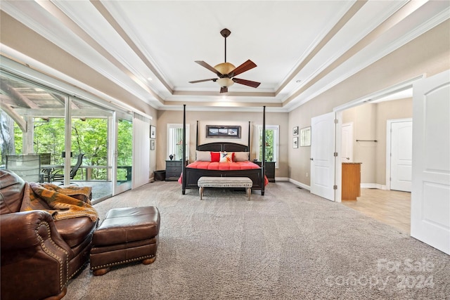 bedroom with ornamental molding, multiple windows, and a tray ceiling