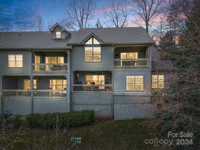 back house at dusk with a balcony