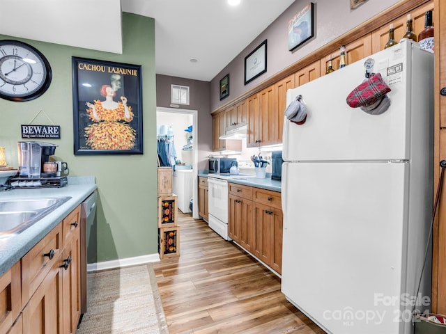 kitchen featuring white appliances, sink, and light wood-type flooring