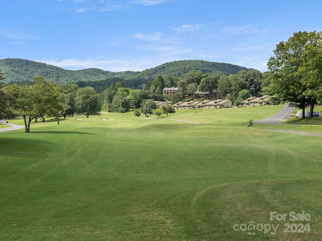 surrounding community with a mountain view and a lawn