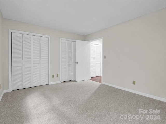 unfurnished bedroom featuring multiple closets