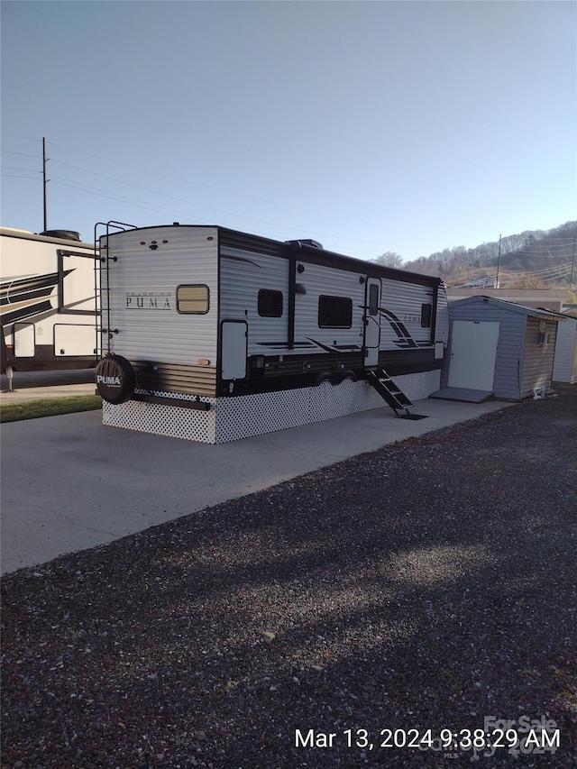 view of front of property featuring a shed