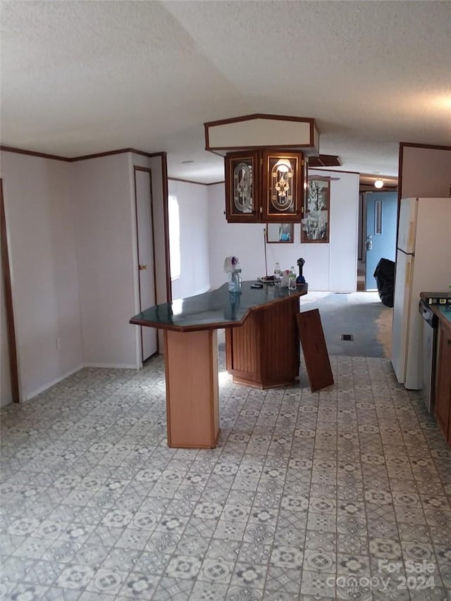 kitchen featuring light tile flooring, a center island, white fridge, and a textured ceiling