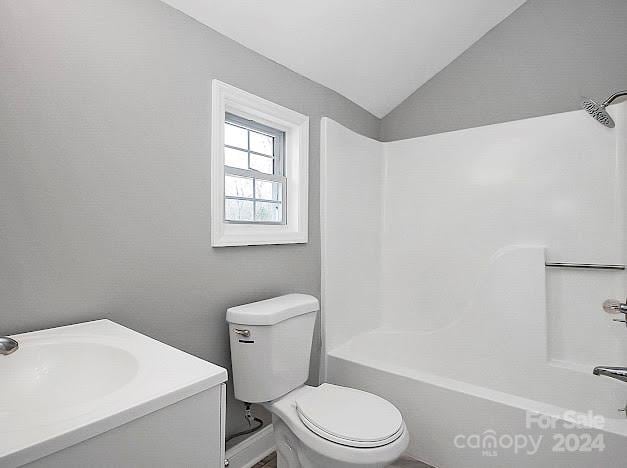 full bathroom featuring vaulted ceiling, vanity, washtub / shower combination, and toilet