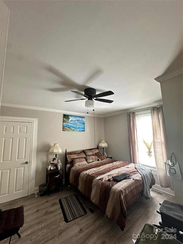 bedroom with wood-type flooring, ornamental molding, and ceiling fan