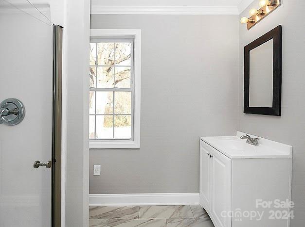 bathroom with vanity, tile patterned floors, crown molding, and plenty of natural light