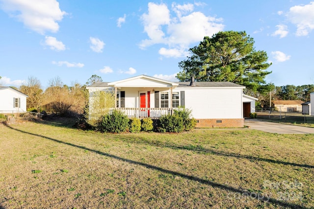 view of front of property with a porch, a garage, and a front lawn