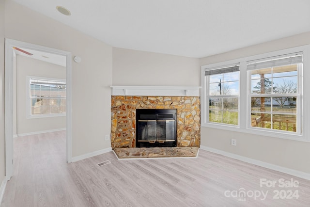 unfurnished living room featuring a fireplace and light hardwood / wood-style floors