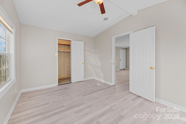 unfurnished bedroom featuring lofted ceiling with beams, ceiling fan, and light wood-type flooring