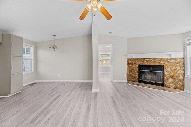 unfurnished living room with vaulted ceiling, ceiling fan, a fireplace, and light hardwood / wood-style floors