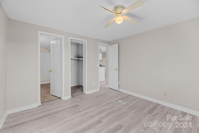 unfurnished bedroom with a closet, connected bathroom, ceiling fan, and light hardwood / wood-style flooring