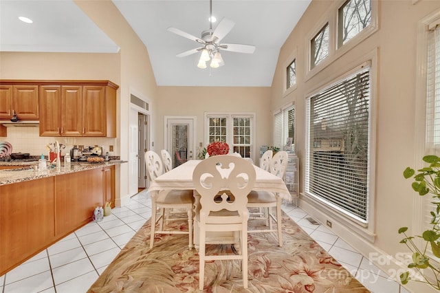 tiled dining room with high vaulted ceiling and ceiling fan