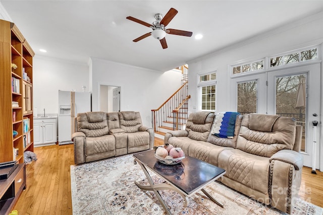 living room with ceiling fan, crown molding, light hardwood / wood-style flooring, and a healthy amount of sunlight