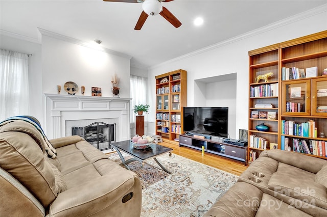 living room featuring ceiling fan, light hardwood / wood-style flooring, ornamental molding, and plenty of natural light