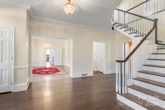 entrance foyer featuring crown molding, dark wood-type flooring, and a notable chandelier