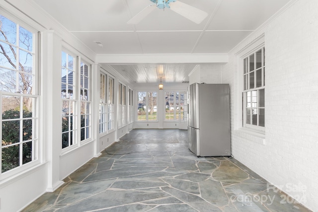 unfurnished sunroom with ceiling fan