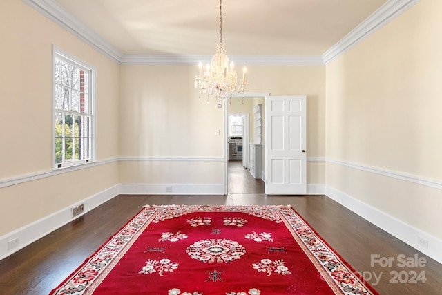 empty room featuring dark hardwood / wood-style flooring, crown molding, and an inviting chandelier