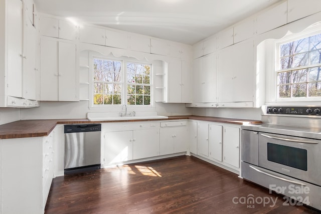 kitchen with dark hardwood / wood-style flooring, appliances with stainless steel finishes, white cabinetry, and wooden counters