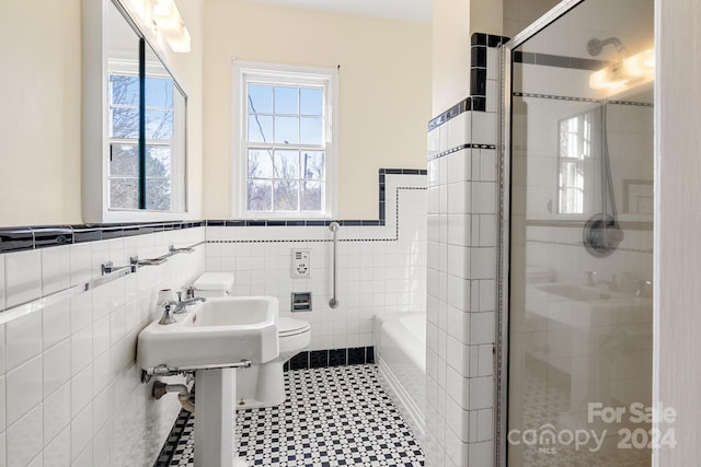 bathroom with tile walls, tile floors, toilet, and separate shower and tub