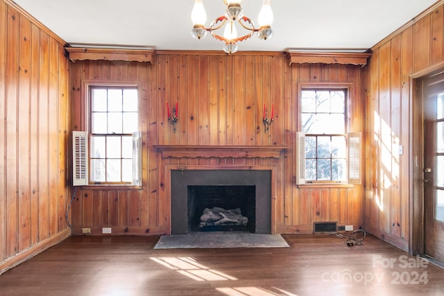 unfurnished living room featuring a wealth of natural light, wood-type flooring, and wooden walls