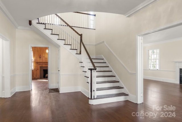 stairway with ornamental molding and dark hardwood / wood-style floors