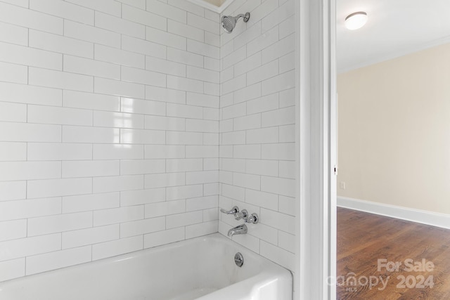 bathroom featuring wood-type flooring and tiled shower / bath combo