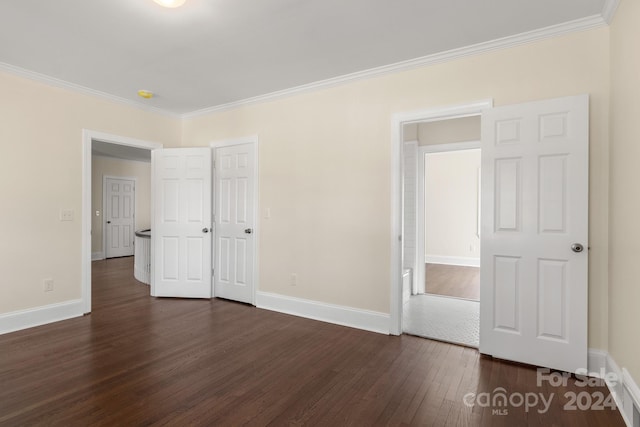 empty room featuring crown molding and dark hardwood / wood-style floors